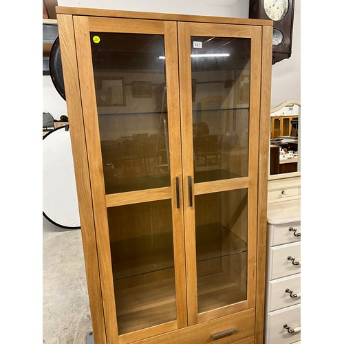 357 - MODERN TWO DOOR GLAZED OAK DISPLAY CABINET WITH TWO DRAWERS TO BASE W36