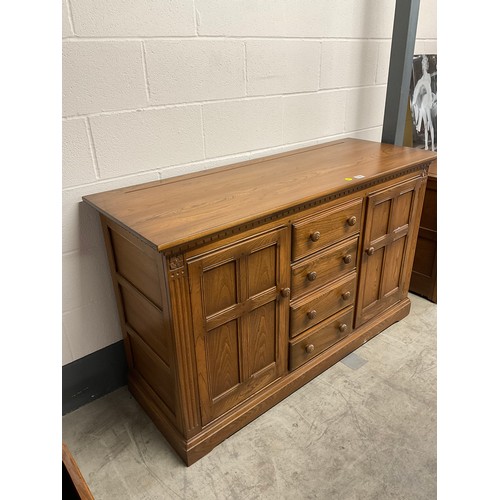 394 - VINTAGE BADGED ERCOL SIDE BOARD FOUR CENTRAL DRAWERS AND CUPBOARD TO EACH END W57