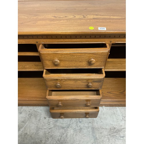 394 - VINTAGE BADGED ERCOL SIDE BOARD FOUR CENTRAL DRAWERS AND CUPBOARD TO EACH END W57