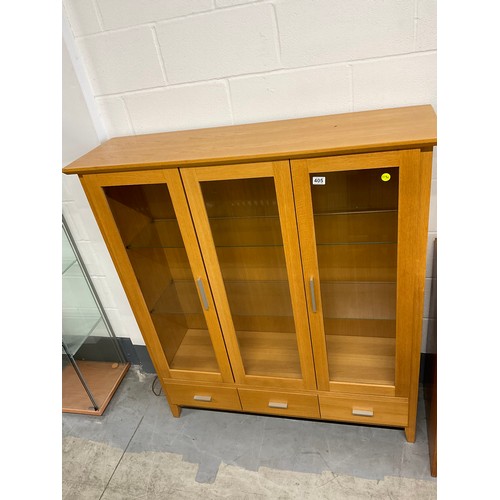 405 - MODERN GOLDEN OAK THREE DOOR GLAZED DISPLAY CABINET WITH THREE DRAWERS TO BASE W50