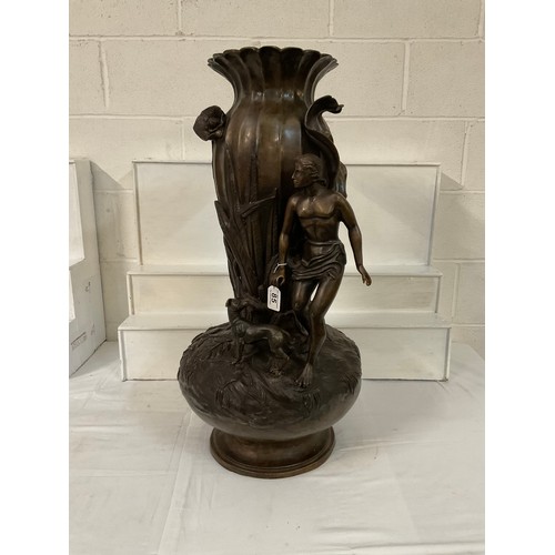 85 - SOLID HEAVY BRONZE VASE DECORATED WITH FOILAGE MAN AND HIS DOG (DOG IS LOOSE) H31”