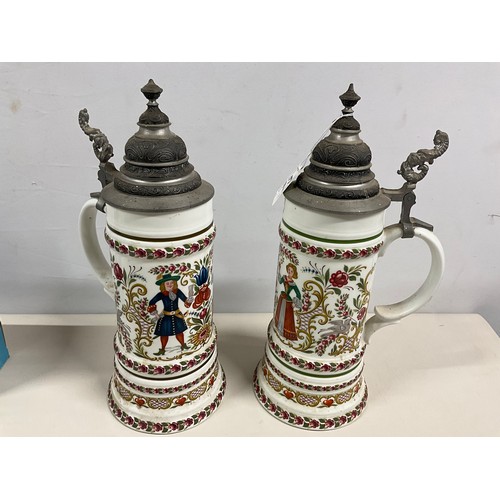 73 - PAIR OF LARGE GERMAN HAND PAINTED STEINS DECORATED COMPLETE WITH COVER H13