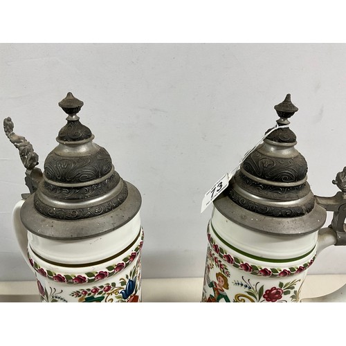 73 - PAIR OF LARGE GERMAN HAND PAINTED STEINS DECORATED COMPLETE WITH COVER H13