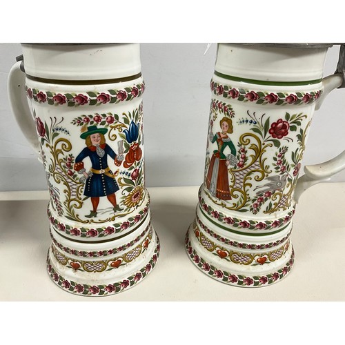 73 - PAIR OF LARGE GERMAN HAND PAINTED STEINS DECORATED COMPLETE WITH COVER H13