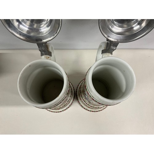 73 - PAIR OF LARGE GERMAN HAND PAINTED STEINS DECORATED COMPLETE WITH COVER H13