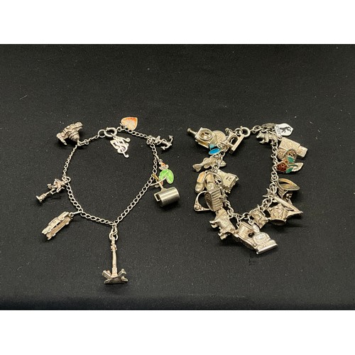 8 - 2 SILVER CHARM BRACELETS UNMARKED CHAIN BUT TESTED WITH A TOTAL OF 33 SILVER CHARMS W83.6G - 1 CHARM... 