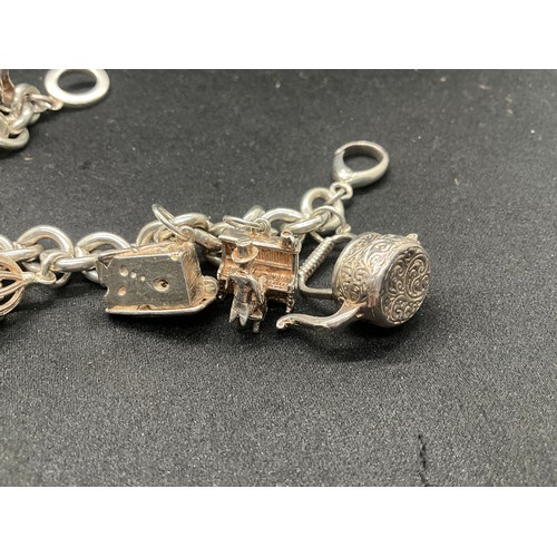 11 - SILVER CHARM BRACELET MARKED BUT HEAVILY RUBBED BUT TESTED WITH 9 SILVER CHARMS TW94.1G