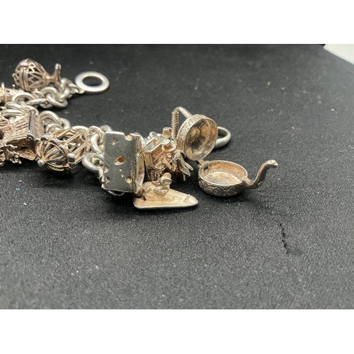 11 - SILVER CHARM BRACELET MARKED BUT HEAVILY RUBBED BUT TESTED WITH 9 SILVER CHARMS TW94.1G