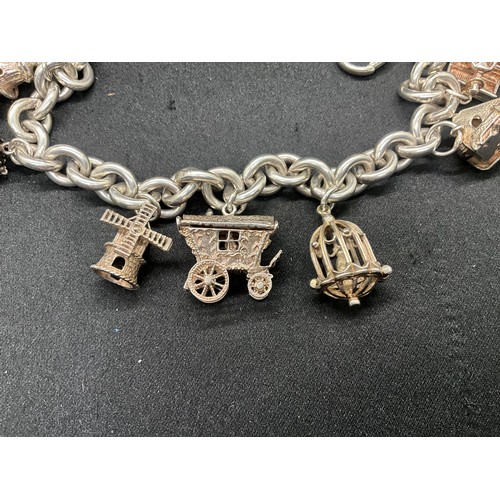 11 - SILVER CHARM BRACELET MARKED BUT HEAVILY RUBBED BUT TESTED WITH 9 SILVER CHARMS TW94.1G