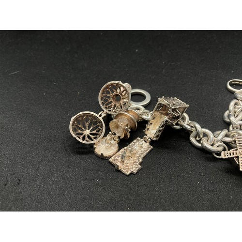 11 - SILVER CHARM BRACELET MARKED BUT HEAVILY RUBBED BUT TESTED WITH 9 SILVER CHARMS TW94.1G
