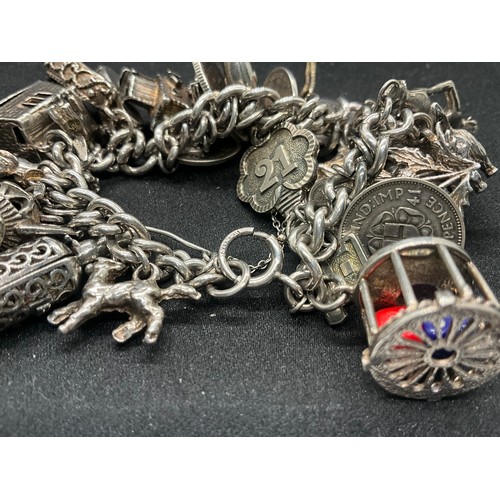 16 - SILVER CHARM BRACELET HALLMARKED WITH 27 SILVER CHARMS AND 1 ADDITIONAL CHARM NOT SILVER TW91.6G - I... 