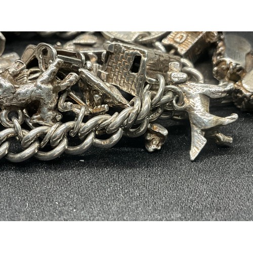 16 - SILVER CHARM BRACELET HALLMARKED WITH 27 SILVER CHARMS AND 1 ADDITIONAL CHARM NOT SILVER TW91.6G - I... 