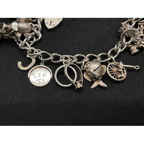 28 - 2 SILVER CHARM BRACELETS (TESTED) WITH A TOTAL OF 30 SILVER & WHITE METAL CHARMS TW104.2G
1 IS ENGLI... 