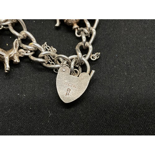 28 - 2 SILVER CHARM BRACELETS (TESTED) WITH A TOTAL OF 30 SILVER & WHITE METAL CHARMS TW104.2G
1 IS ENGLI... 