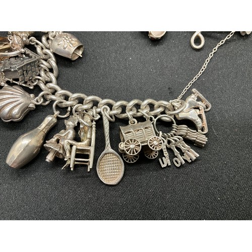 31 - HALLMARKED SILVER CHARM BRACELET WITH 29 SILVER & WHITE METAL CHARMS W87.9G - LOCKET & CHAIN ENGLISH... 