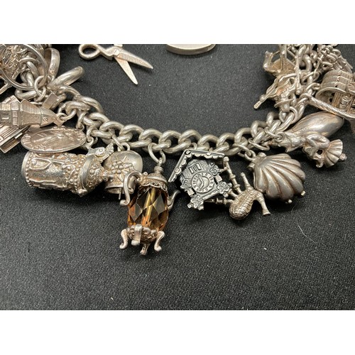 31 - HALLMARKED SILVER CHARM BRACELET WITH 29 SILVER & WHITE METAL CHARMS W87.9G - LOCKET & CHAIN ENGLISH... 
