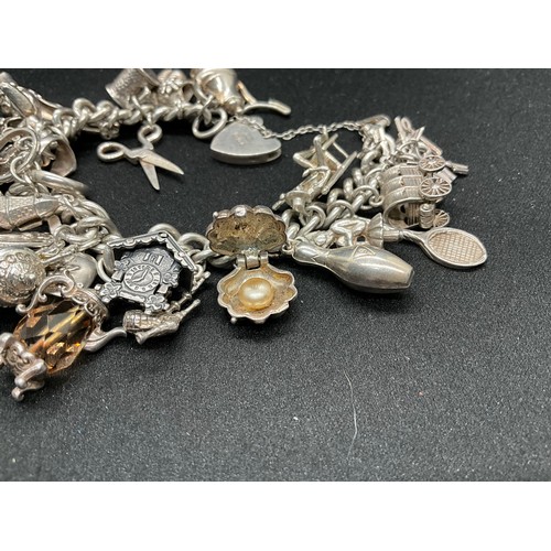 31 - HALLMARKED SILVER CHARM BRACELET WITH 29 SILVER & WHITE METAL CHARMS W87.9G - LOCKET & CHAIN ENGLISH... 