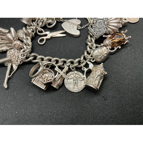 31 - HALLMARKED SILVER CHARM BRACELET WITH 29 SILVER & WHITE METAL CHARMS W87.9G - LOCKET & CHAIN ENGLISH... 
