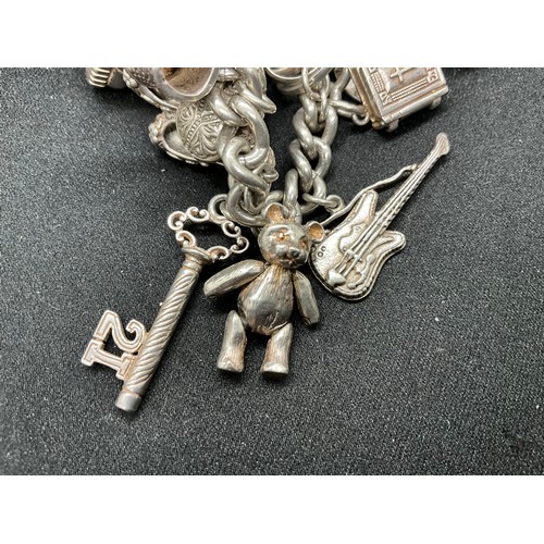 31 - HALLMARKED SILVER CHARM BRACELET WITH 29 SILVER & WHITE METAL CHARMS W87.9G - LOCKET & CHAIN ENGLISH... 
