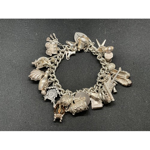 31 - HALLMARKED SILVER CHARM BRACELET WITH 29 SILVER & WHITE METAL CHARMS W87.9G - LOCKET & CHAIN ENGLISH... 