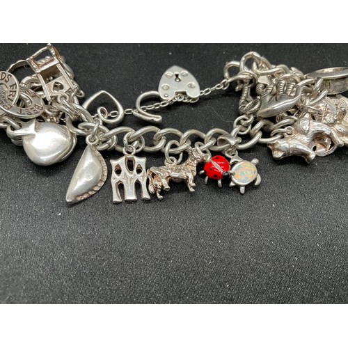 43 - SILVER CHARM BRACELET (TESTED) WITH 24 SILVER CHARMS TW54G 2 CHARMS HELD IN PLACE WITH PLATED HOOPS ... 