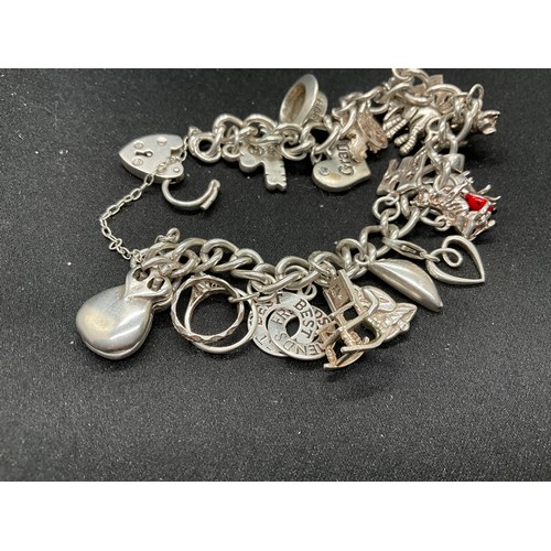 43 - SILVER CHARM BRACELET (TESTED) WITH 24 SILVER CHARMS TW54G 2 CHARMS HELD IN PLACE WITH PLATED HOOPS ... 