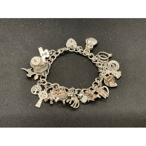 43 - SILVER CHARM BRACELET (TESTED) WITH 24 SILVER CHARMS TW54G 2 CHARMS HELD IN PLACE WITH PLATED HOOPS ... 
