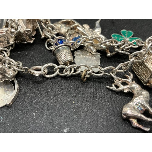 49 - 2 SILVER CHARM BRACELETS (TESTED) WITH A TOTAL OF 25 SILVER & WHITE METAL CHARMS TW69.6G - 1 LOCKET ... 