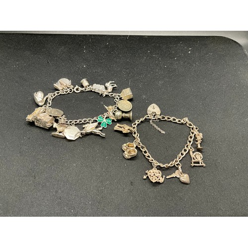 49 - 2 SILVER CHARM BRACELETS (TESTED) WITH A TOTAL OF 25 SILVER & WHITE METAL CHARMS TW69.6G - 1 LOCKET ... 