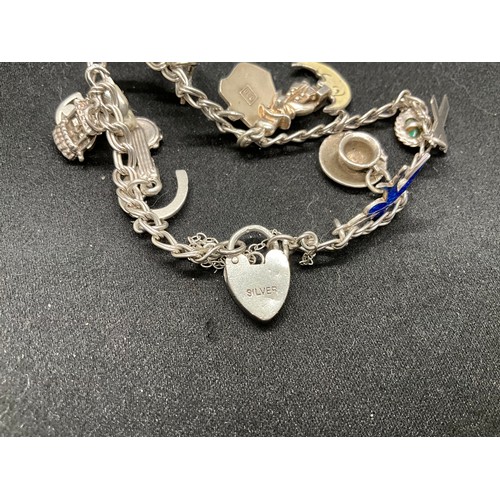 52 - 2 SILVER CHARM BRACELETS (TESTED) WITH A TOTAL OF 20 SILVER & WHITE METAL CHARMS W38.4G - BOTH LOCKE... 