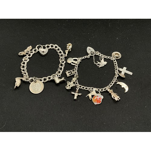 52 - 2 SILVER CHARM BRACELETS (TESTED) WITH A TOTAL OF 20 SILVER & WHITE METAL CHARMS W38.4G - BOTH LOCKE... 
