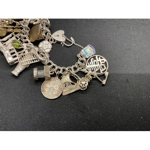 57 - SILVER CHARM BRACELET (TESTED) WITH 23 SILVER & WHITE METAL CHARMS AND 1 COIN CHARM PLATED W72.5G -L... 
