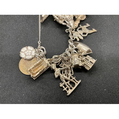 57 - SILVER CHARM BRACELET (TESTED) WITH 23 SILVER & WHITE METAL CHARMS AND 1 COIN CHARM PLATED W72.5G -L... 