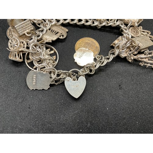 57 - SILVER CHARM BRACELET (TESTED) WITH 23 SILVER & WHITE METAL CHARMS AND 1 COIN CHARM PLATED W72.5G -L... 