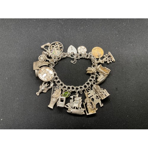 57 - SILVER CHARM BRACELET (TESTED) WITH 23 SILVER & WHITE METAL CHARMS AND 1 COIN CHARM PLATED W72.5G -L... 