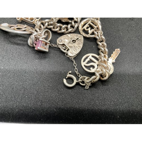 58 - 2 SILVER CHARM BRACELETS (TESTED) WITH A TOTAL OF 25 SILVER & WHITE METAL CHARMS ADDITIONAL CHARM PL... 