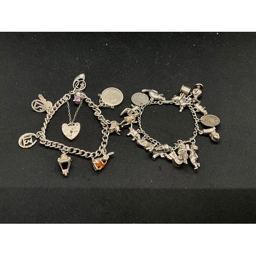 58 - 2 SILVER CHARM BRACELETS (TESTED) WITH A TOTAL OF 25 SILVER & WHITE METAL CHARMS ADDITIONAL CHARM PL... 
