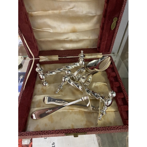 89 - Case containing silver-plated knife rests, caddy spoons etc