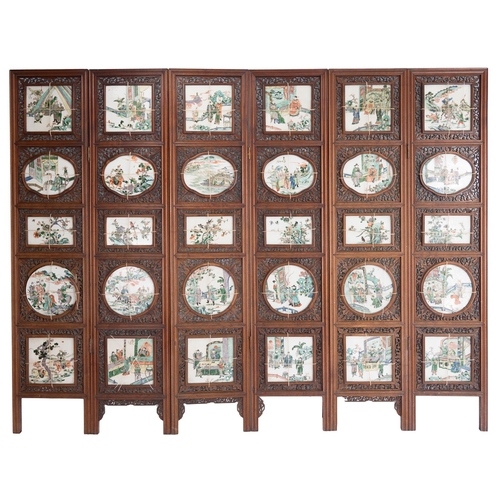 A large and impressive late qing dynasty chinese hardwood six-fold screen with pierced scrolling decoration inserted with thirty chinese porcelain plaques depicting various scenes. each panel: height 193 x width 42 cm. total length when opened approx. 252cm length

 provenance: english private owner - acquired in india by the vendors grandfather (e. b. raikes, k.c.) who practised in bombay between 1890 and 1911 and thence by descent.