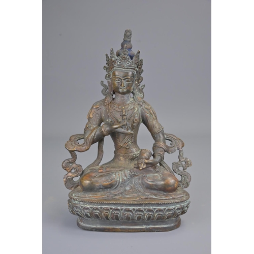 327 - A tibetan bronze figure of seated buddha holding vajra. height 23cm