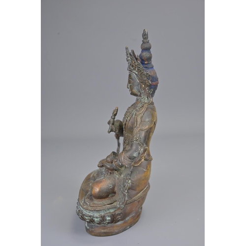 327 - A tibetan bronze figure of seated buddha holding vajra. height 23cm