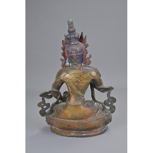 327 - A tibetan bronze figure of seated buddha holding vajra. height 23cm