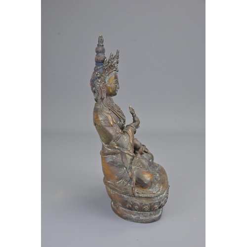 327 - A tibetan bronze figure of seated buddha holding vajra. height 23cm