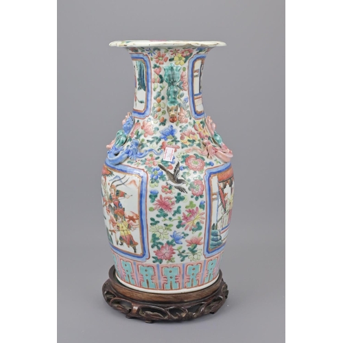 41 - A 19th century chinese cantonese porcelain vase. with a later wooden stand. height approx. 35cm.