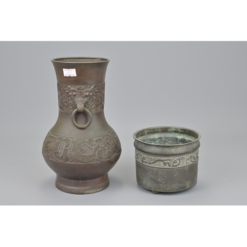 48 - A chinese bronze censer with shallow tripod feet together with a gu vase with twin looped handles an... 