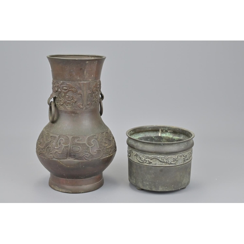 48 - A chinese bronze censer with shallow tripod feet together with a gu vase with twin looped handles an... 