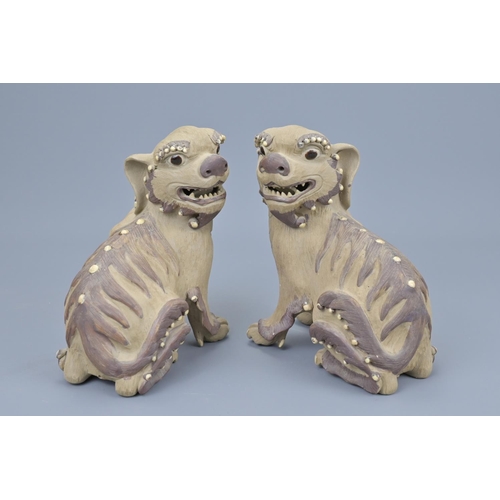 63 - Pair of chinese pottery lions. height approx. 17cm (2)