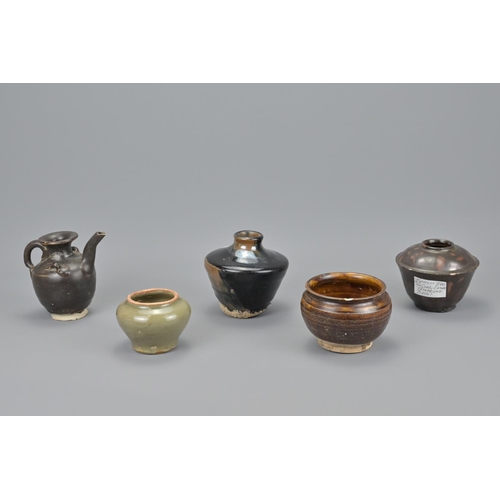 75 - Four chinese song to ming black glazed pots together with a yuan dynasty celadon pot. `teapot height... 