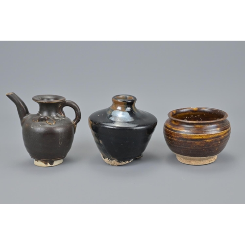 75 - Four chinese song to ming black glazed pots together with a yuan dynasty celadon pot. `teapot height... 