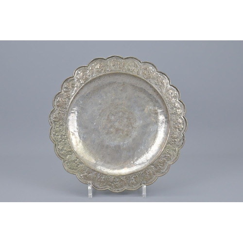 76 - An indian embossed white metal dish. diameter approx. 26cm